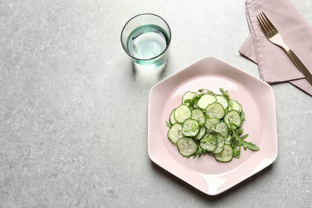 Plate with delicious cucumber salad served on grey table, top view. Space for text - Fotoğraf, Görsel