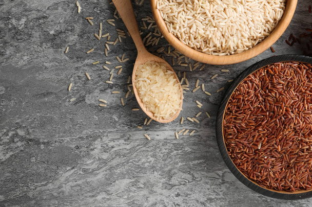 Flat lay composition with brown and other types of rice on grunge background. Space for text - Fotó, kép