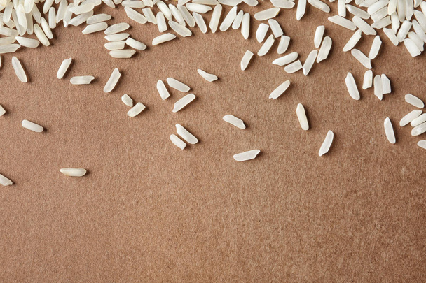 Long grain rice on color background, top view with space for text - Valokuva, kuva