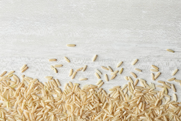 Brown rice on wooden background, top view with space for text - Foto, immagini