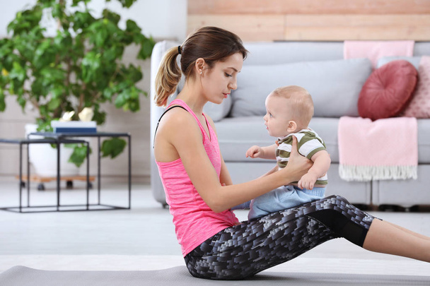 Young sportive woman doing exercise with her son at home. Fitness training - Fotoğraf, Görsel