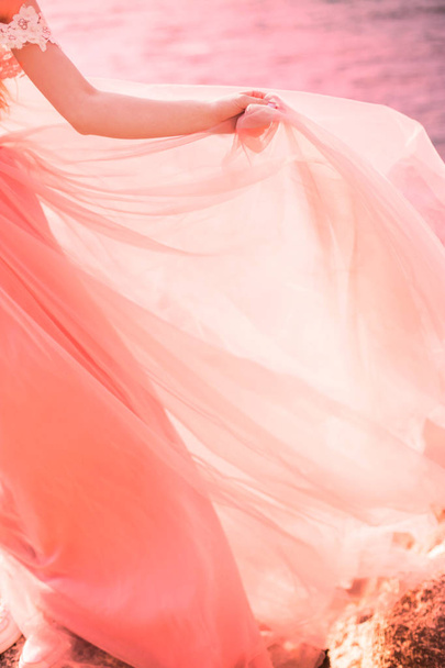The bride is wearing a wedding dress gently coral color on the sea. Beautiful tulle. The concept of fashion colors 2019 - Photo, Image