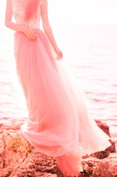 Beautiful bride in a long pink wedding dress on the sea. The concept of fashion colors 2019, living coral - Foto, Imagen