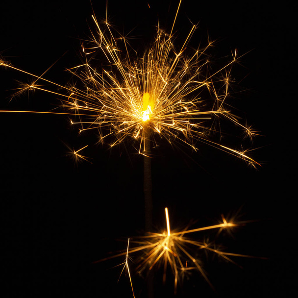 Christmas sparkler isolated on black background. Bengal fire close up - Foto, afbeelding