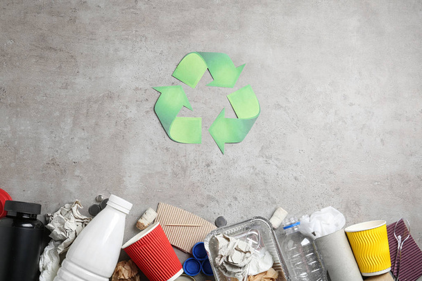 Recycling symbol and different garbage on gray background, top view - Fotografie, Obrázek