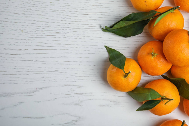 Fresh ripe tangerines and space for text on wooden background, top view - Foto, immagini