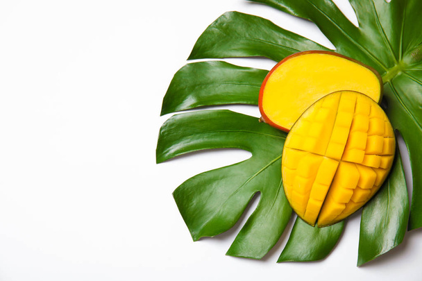 Juicy mango and green tropical leaf isolated on white, top view. Space for text - Foto, imagen