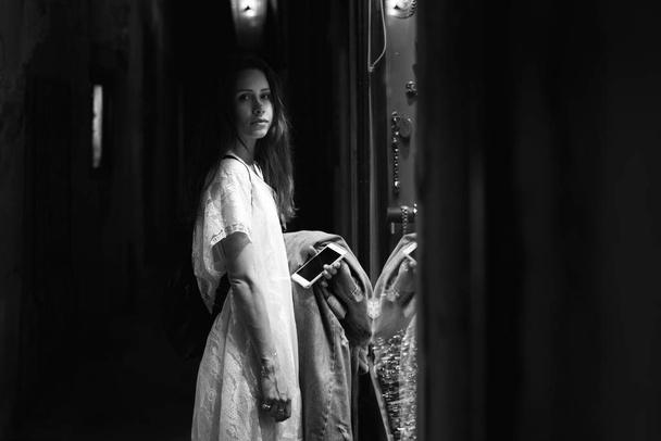 menina está em pé perto da vitrine de uma joalharia
 - Foto, Imagem