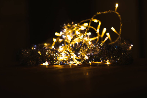 Christmas luminous garland on a dark background. - Fotoğraf, Görsel