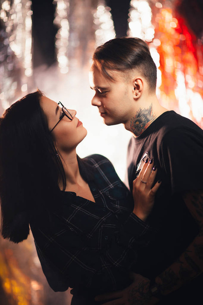 Couple in fashionable clothes on a shiny background. - 写真・画像