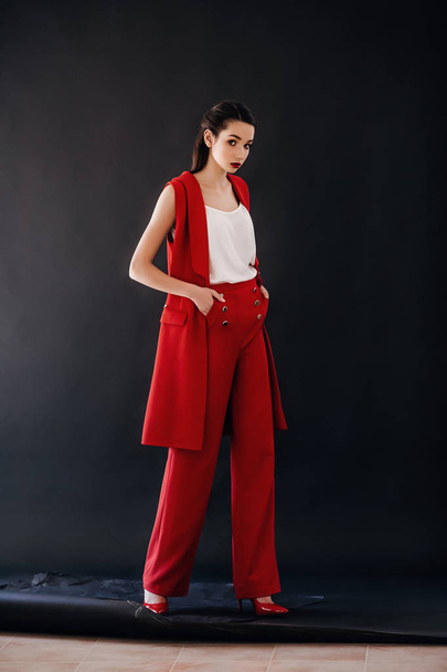 Beautiful young woman posing in  red pants posing in studio - Valokuva, kuva