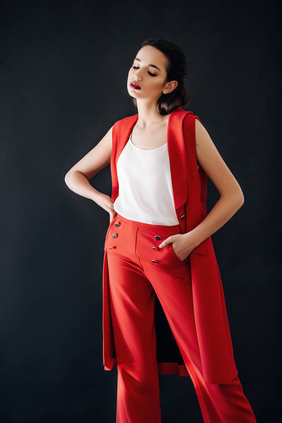 Piękna młoda kobieta stwarzających w czerwone spodnie pozowanie Studio - Zdjęcie, obraz