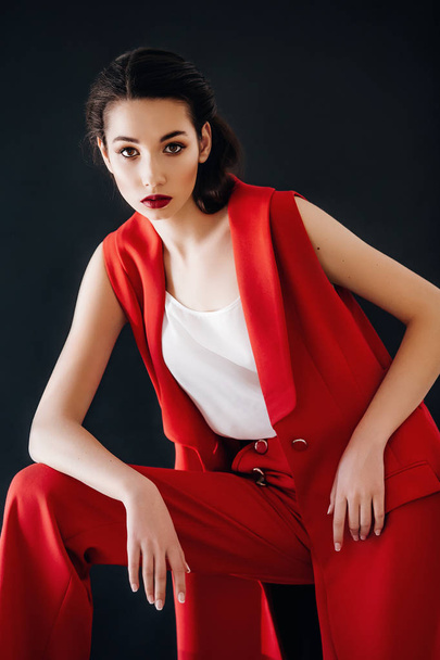 Kaunis nuori nainen poseeraa punaiset housut poseeraa studiossa
 - Valokuva, kuva