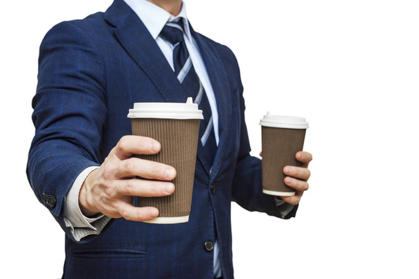 Businessman offering coffee in paper cup. Businessman offers a cup of coffee. Businessman holding two disposable coffee cup - Photo, image