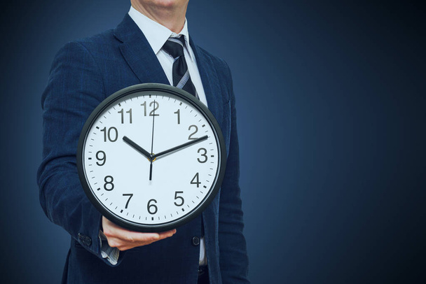 Clock in businessman hand. Businessman with a clock in a hand. Businessman with clock in time concept - Photo, Image