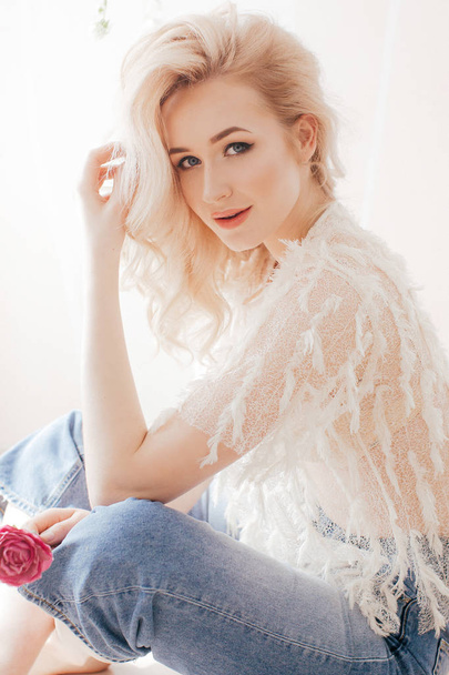 Beautiful young woman posing in white blouse and jeans - Fotografie, Obrázek