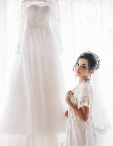 Gyönyörű fiatal menyasszony pózol, fehér menyasszonyi ruha  - Fotó, kép