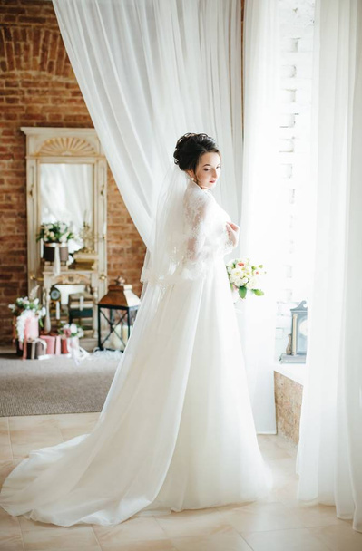 Красивая молодая невеста в белом свадебном платье позирует
  - Фото, изображение