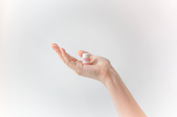 many pills in hand, white and pink round pills on woman's palm - Фото, изображение