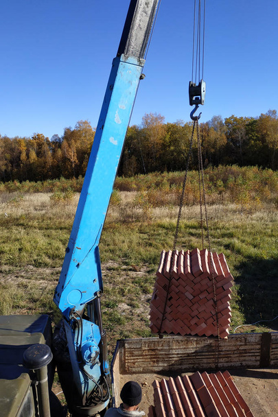 Вантажний кран розвантажує цеглу для будівництва будинку 2018
 - Фото, зображення