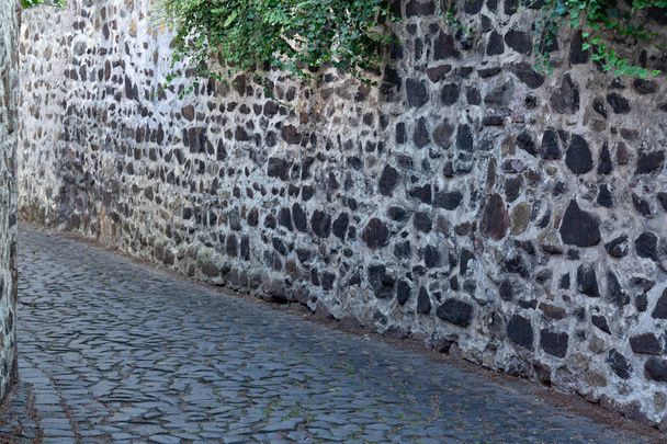 Ένα στενό δρόμο μεταξύ τους τοίχους με έναν Τοιχοποιία από σκοτεινή πέτρα - Φωτογραφία, εικόνα