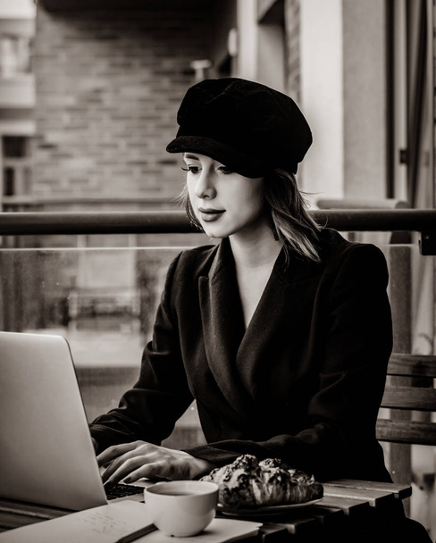 Bela jovem empresária trabalhando no laptop enquanto está sentado ao ar livre em casa. Conceito de trabalho com startup business. Imagem em estilo de cor preto e branco
 - Foto, Imagem