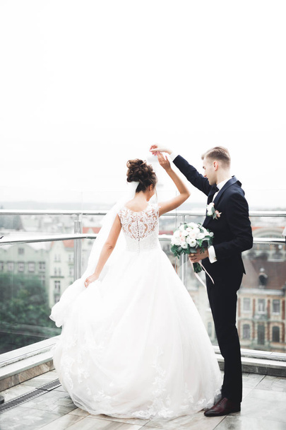 Beautiful bride spinning with perfect dress on the balcony - Φωτογραφία, εικόνα