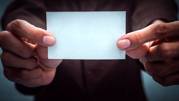 Businessman holding white business card. Mockup bank paper for ads and text. - Foto, Imagem