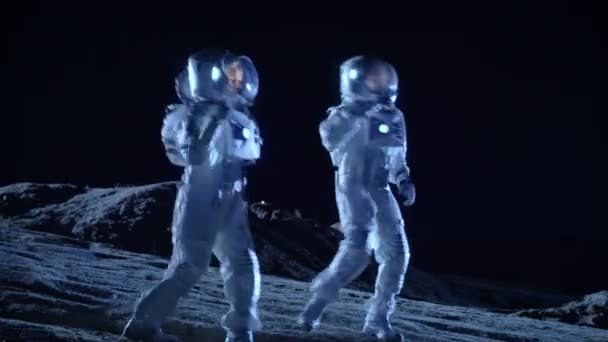 Astronautinnen und Astronauten in Raumanzügen tanzen auf der Oberfläche des außerirdischen Planeten. Menschlichkeit kolonisiert das Thema der Weltraumfeier. - Filmmaterial, Video
