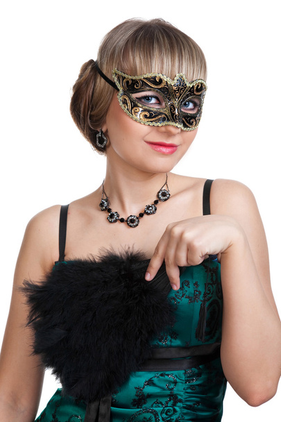 Beautiful girl in green evening dress with necklace and earrings in carnival mask hodling fan - Photo, Image