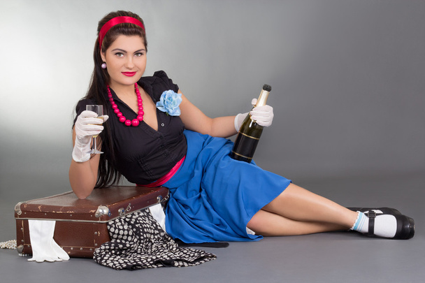 plakát dívka s lahví šampaňského a zabalený kufr - Fotografie, Obrázek