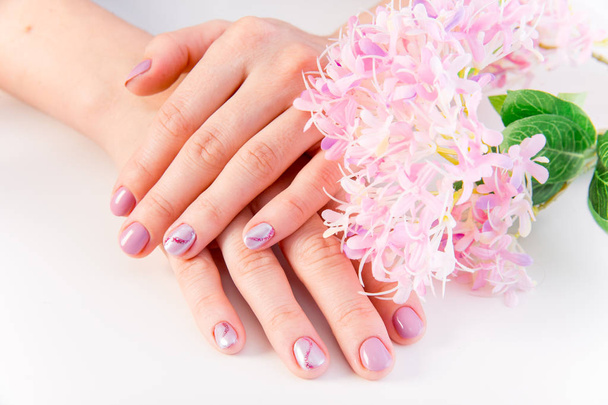 female hand skin care - hands holding flowers - Foto, Imagen