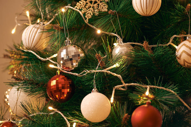 Close-up van gedecoreerde kerstboom met lampjes - Foto, afbeelding