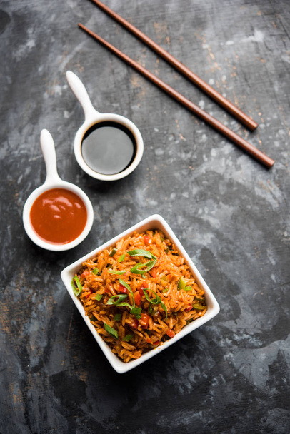 Schezwan Смажений рис масала є популярним Індо китайський їжі подаються в тарілку або миску з паличками для їжі. Вибірковий фокус - Фото, зображення
