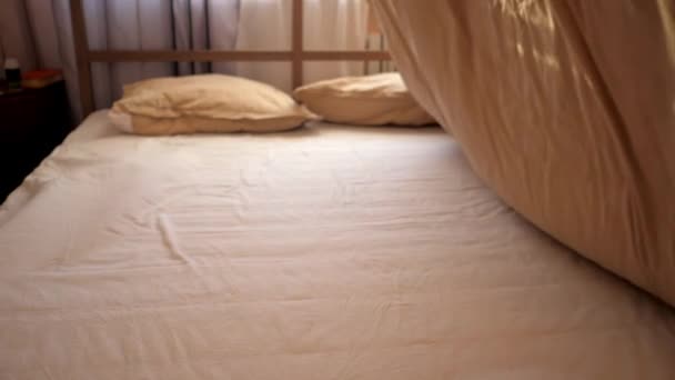person shakes blanket like sail and puts on double bed - Felvétel, videó