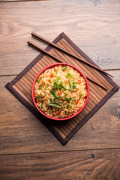 Schezwan Смажений рис масала є популярним Індо китайський їжі подаються в тарілку або миску з паличками для їжі. Вибірковий фокус - Фото, зображення