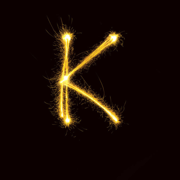 Alphabet sparklers on black background single letter - 写真・画像