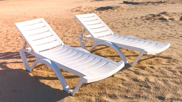Two sunlongers on the sand beach in summer. - Фото, изображение