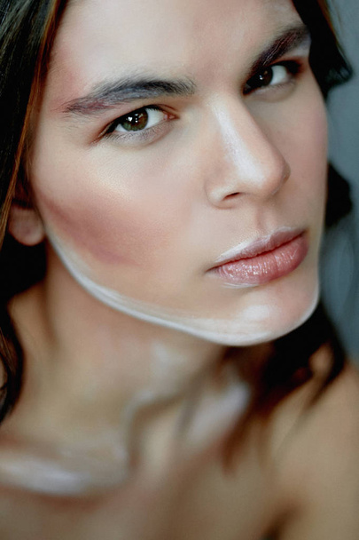 Girl model with creative makeup, paint strokes on the face.Creative person. Living sculpture. Thoughtful look - Foto, Bild