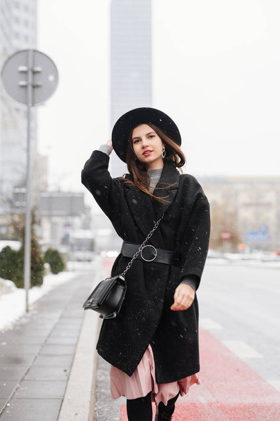 Young fashion woman walking on the city street wear black hat look around and smile to camera. Copy space. - Image - Fotó, kép