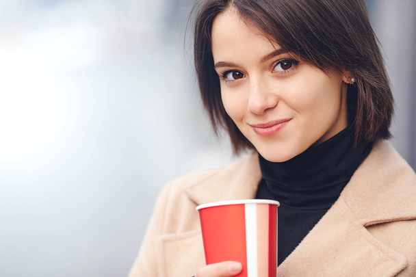 Woman Drink Her Hot Coffee While Walking On The Street. Portrait Of Stylish Smiling Woman In Winter Clothes Drinking Hot Coffee. Female Winter Style. - Image - Фото, зображення
