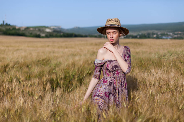 eine Bäuerin mit Hut auf dem Feld der reifen Weizenernte - Foto, Bild