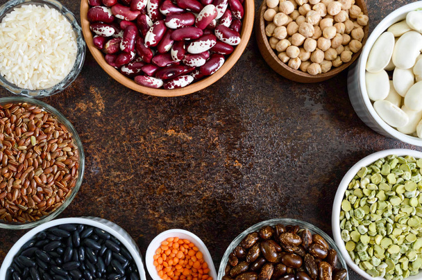 Healthy food, dieting, nutrition concept, vegan protein source. Assortment of colorful raw legumes: lentils, green peas, beans, chickpeas, rice in bowls. Background. Free space. - Photo, Image