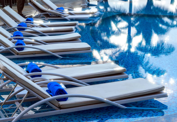 Ξαπλώστρες με σπα κοντά σε μια πισίνα για να χαλαρώσετε τα τροπικά παραλιακά θέρετρα - Φωτογραφία, εικόνα