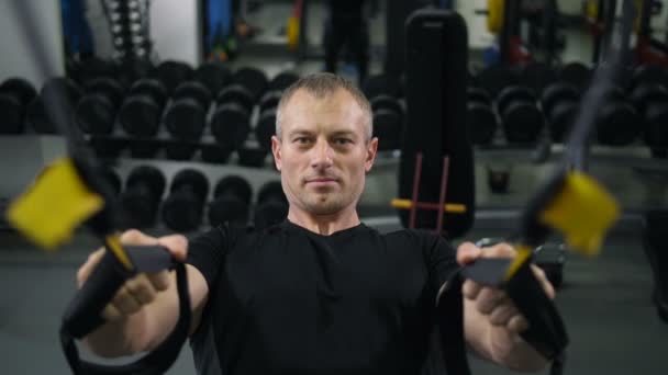 Muscular man pulls himself up on TRX belts - Footage, Video