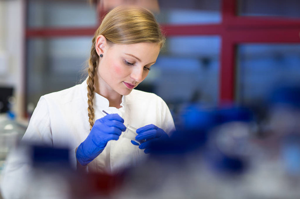 Portrait of a female researcher carrying out research in a chemistry lab (color toned image; shallow DOF) - Fotó, kép