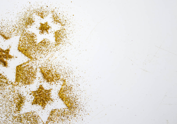 Stars glitter pattern gold and white background. Abstract bright golden design for wallpaper, Christmas decoration. Symbol of holiday - Photo, image