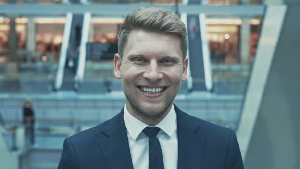 Smiling young man in the mall - Materiał filmowy, wideo