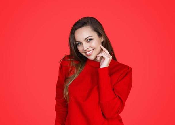 Beautiful smiling brunette on red background - Photo, Image
