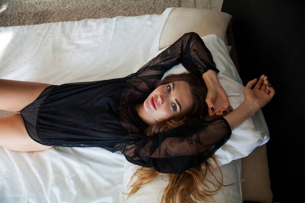 красива жінка в нижній білизні лежить на ліжку в спальні
 - Фото, зображення